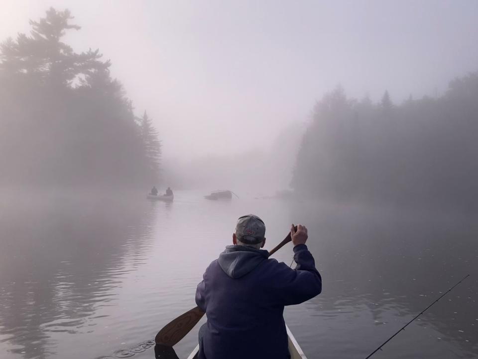 Heavy fog adds to the serene morning as Ed, Dick, Don and Art Holden paddle on the Oswegatchie River in upstate New York.