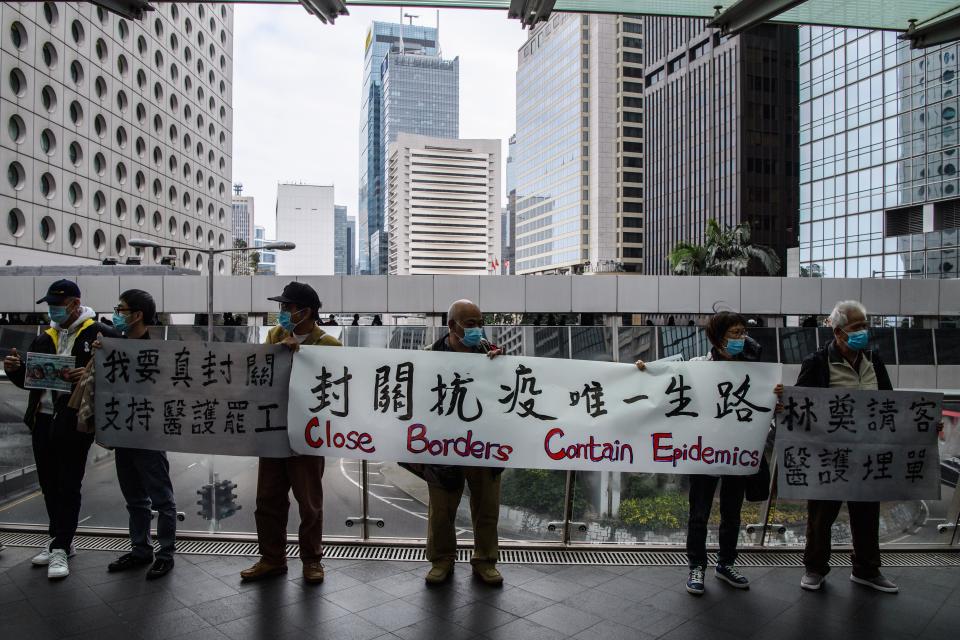 Protesters hold up a banner during a "flash mob" gathering to demand the government close its border with mainland China to reduce the spread of the deadly SARS-like virus to Hong Kong on February 3, 2020. - Hundreds of Hong Kong medical workers walked off their jobs on February 3, demanding the city close its border with China to reduce the coronavirus spreading -- with frontline staff threatening to follow suit in the coming days. (Photo by Anthony WALLACE / AFP) (Photo by ANTHONY WALLACE/AFP via Getty Images)