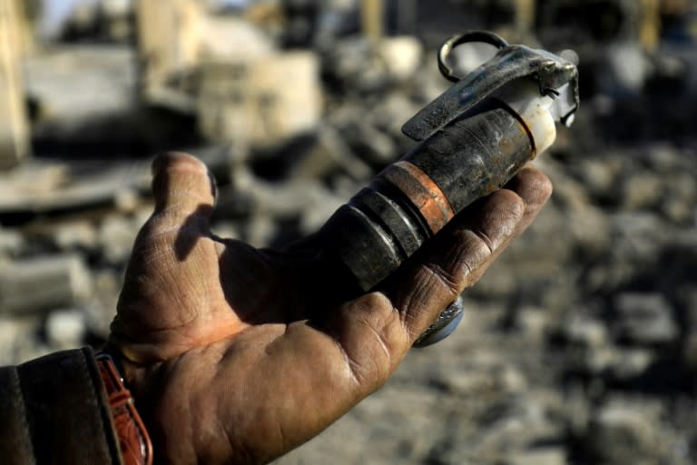 A Syrian man holds an unexploded mine left by the Islamic State group in Raqa