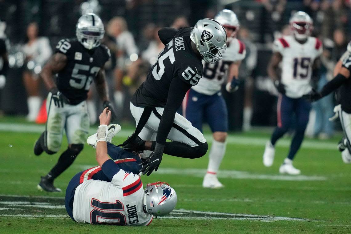 Las Vegas Raiders defensive end Chandler Jones breaks a tackle by New England Patriots quarterback Mac Jones (10) to score a touchdown on an interception during the second half of an NFL game, Sunday, Dec. 18, 2022, in Las Vegas.