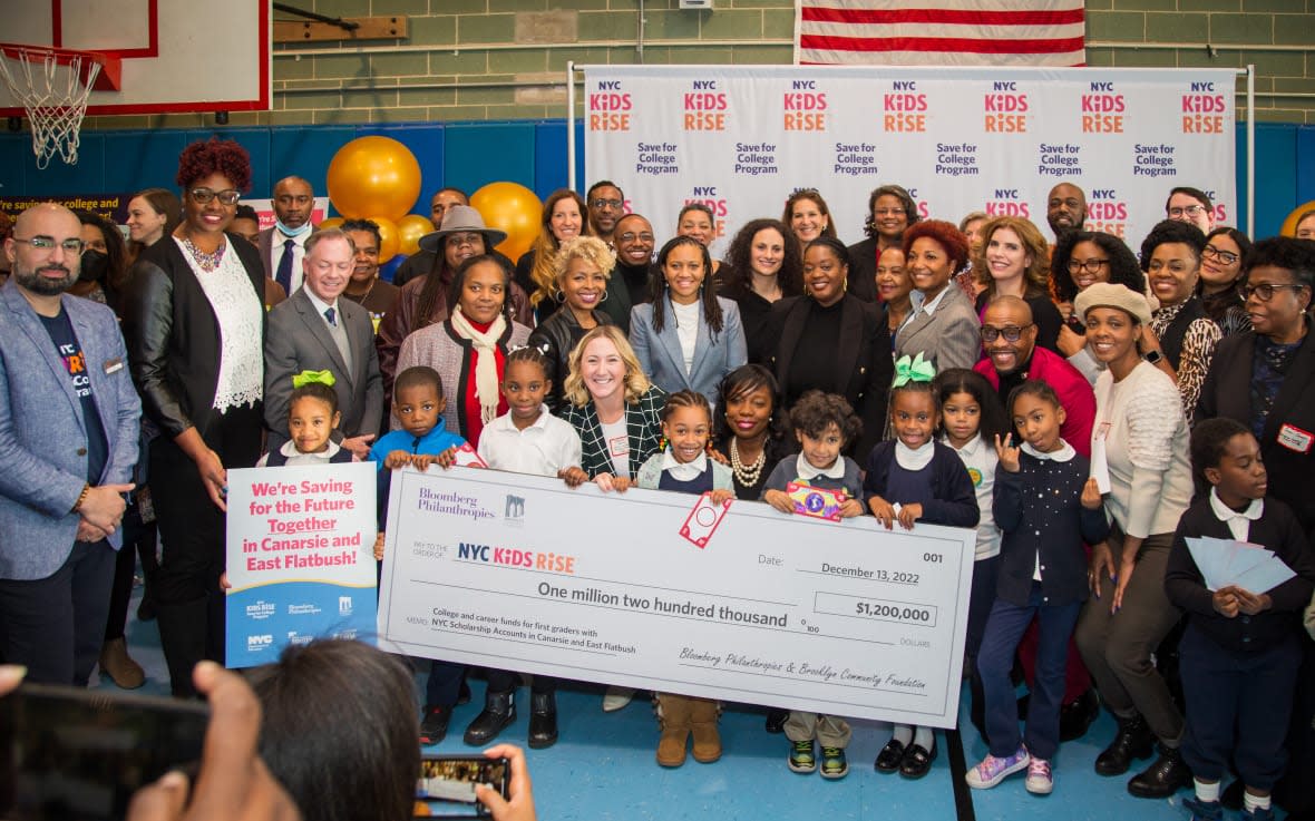 School officials and first graders from East Flatbush and Canarsie celebrate a $1.2 million investment through the Save for College Program into 1,200 first graders’ accounts. Also present on Dec. 13, 2022, were First Deputy Mayor Sheena Wright, Mayor’s Office of Equity Commissioner Sideya Sherman, local elected officials and representatives from NYC Kids RISE, Bloomberg Philanthropies’ Greenwood Initiative, Brooklyn Community Foundation and the Gray Foundation. (Photo credit: Jamon Davis for NYC Kids RISE)