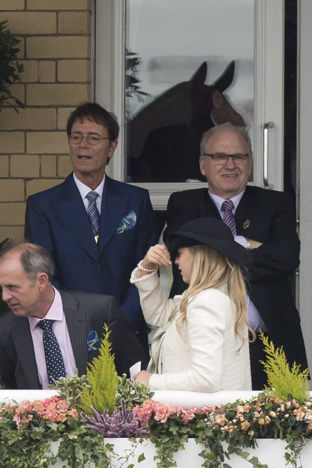 Singer Cliff Richard, upper left, watches racing before the Grand National horse race at Aintree Racecourse Liverpool, England, Saturday, April 5, 2014. (AP Photo/Jon Super)