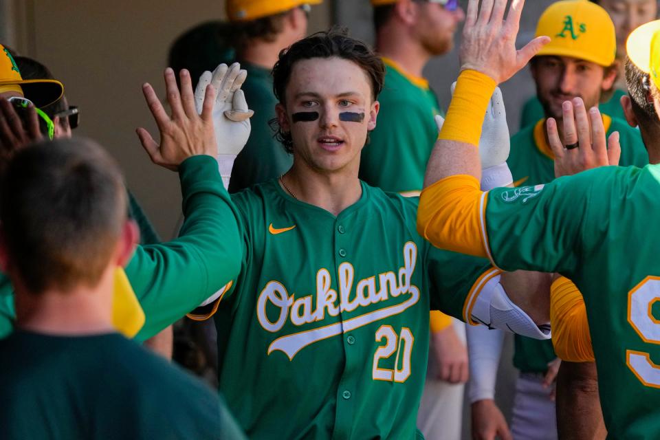 Oakland Athletics second baseman Zack Gelof (20) celebrates in the dugout after hitting a solo home run against the Arizona Diamondbacks in the third inning of a spring game.