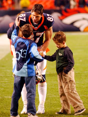 <p>Cyrus McCrimmon/The Denver Post/Getty </p> Ed McCaffrey greets his sons Max McCaffrey and Christian McCaffrey on the field in December 2002.