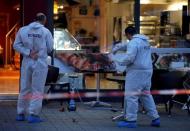 Police forensic experts work outside where a 21-year-old Syrian refugee killed a woman with a machete and injured two other people in the city of Reutlingen, Germany July 24, 2016. REUTERS/Vincent Kessler