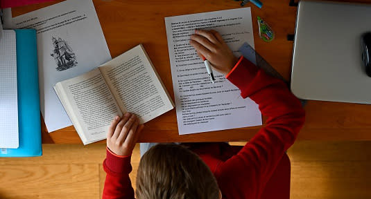 A schoolboy does his homework in his room in Rennes, western France.