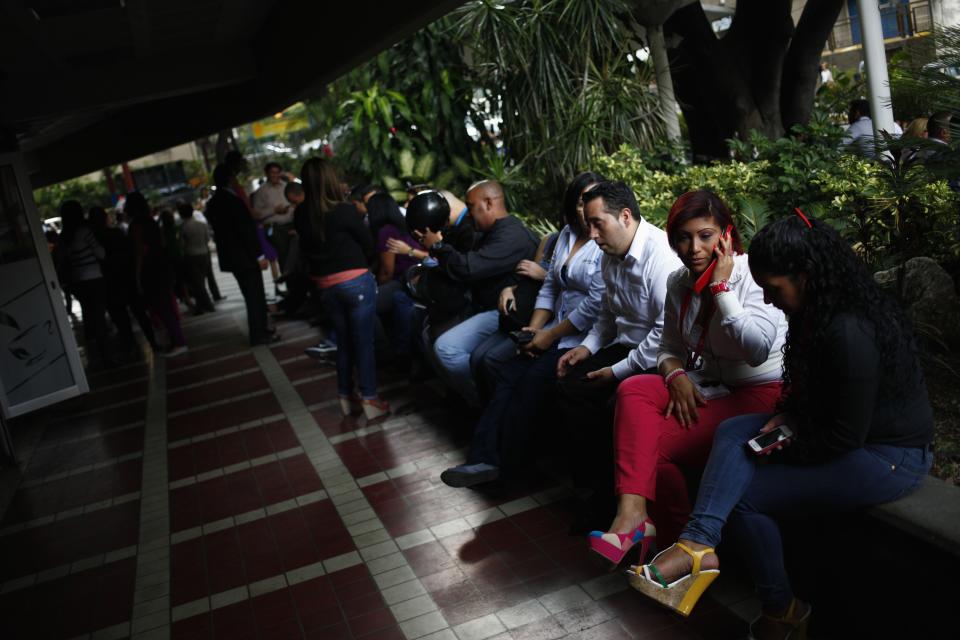 People sit outside a shopping mall during a massive blackout in Caracas September 3, 2013. A blackout hit much of Venezuela including the capital Caracas on Tuesday, but the oil industry was not affected and the government said it expected power to be restored within hours. REUTERS/Jorge Silva (VENEZUELA - Tags: POLITICS DISASTER)