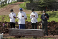 An Islamic cleric leads relatives in prayer during the burial of a man in the special section of Jombang Public Cemetery reserved for those who died of COVID-19, in Tangerang on the outskirts of Jakarta, Indonesia, Monday, June 21, 2021. Indonesia saw significant spikes in confirmed COVID-19 cases recently, an increase blamed on travel during last month's Eid al-Fitr holiday as well as the arrival of new virus variants, such as the the Delta version first found in India. (AP Photo/Tatan Syuflana)