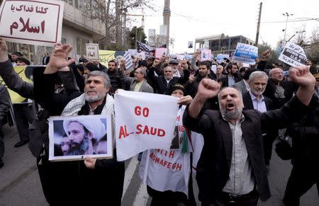 A protester holds a picture of Shi'ite cleric Sheikh Nimr al-Nimr, who was executed in Saudi Arabia, as others chant slogans during a rally after Friday prayers in Tehran January 8, 2016. REUTERS/Raheb Homavandi