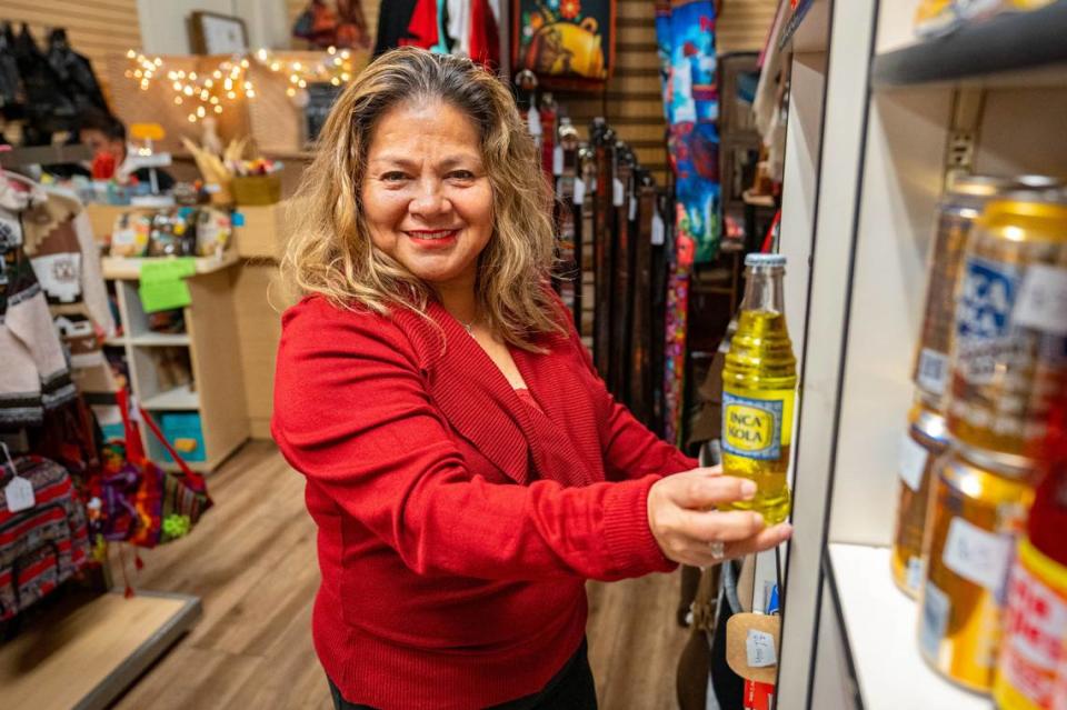 Jessy Luzmila Flores Cárdenas, owner of Mi Tiendita Munaycha in Old Sacramento, grabs a bottle of Inca Kola on Thursday, Nov. 30, 2023.