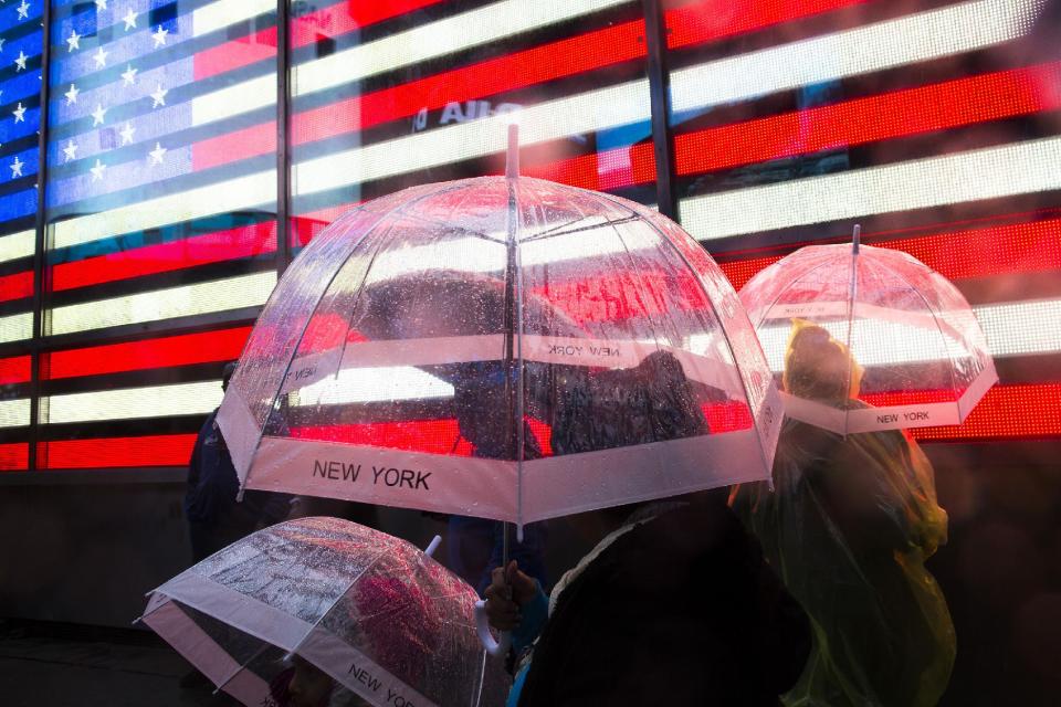 Pedestrians huddle under their umbrellas in Times Square, Monday, Oct. 29, 2012, in New York. Hurricane Sandy continued on its path Monday, as the storm forced the shutdown of mass transit, schools and financial markets, sending coastal residents fleeing, and threatening a dangerous mix of high winds and soaking rain. (AP Photo/ John Minchillo)