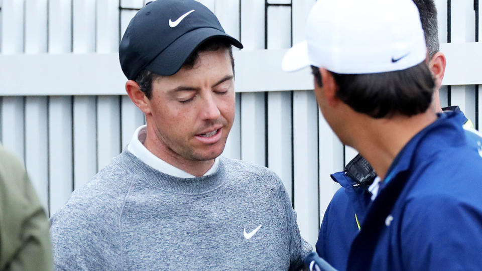 Rory McIlroy leaves the scorer's hut and is consoled by his business manager after missing the cut. (Photo by David Cannon/Getty Images)