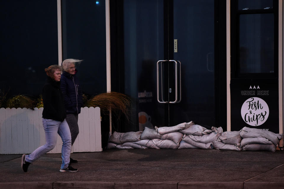 <p>People walk past a sandbagged chip shop during Storm Ophelia in Galway, Ireland, Oct.16, 2017. (Photo: Clodagh Kilcoyne/Reuters) </p>