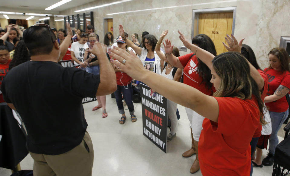 Opponents of the recently passed legislation to tighten the rules on giving exemptions for vaccinations, gather in prayer outside Gov. Gavin Newsom's office after learning Newsom had signed the bill, in Sacramento, Calif., Monday, Sept. 9, 2019. (AP Photo/Rich Pedroncelli)