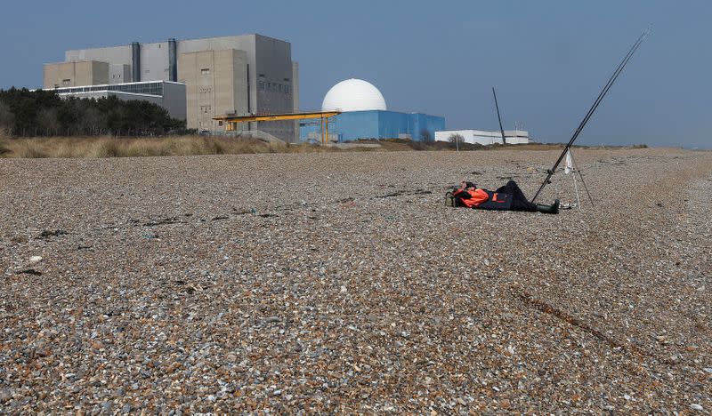 FILE PHOTO: A fisherman takes a nap on Sizewell beach outside Sizewell nuclear power station in Suffolk, eastern England