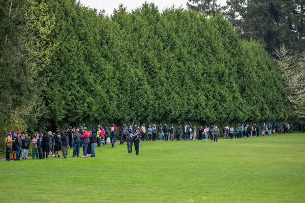 Hundreds of people are pictured waiting in line Wednesday, hoping to get a Pfizer COVID-19 vaccine at Newton Athletic Park in Surrey.