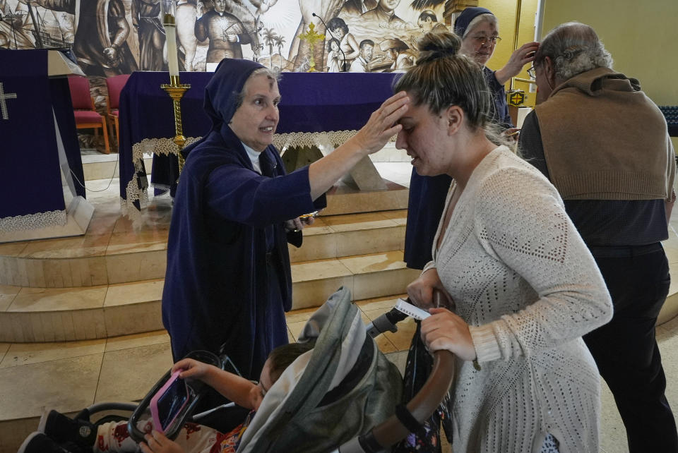 Sister Eva Perez marks Nathalye Parajes' forehead with an ash cross during an Ash Wednesday Mass at the Virgin of Charity shrine, known as La Ermita, in Miami, Florida, Wednesday, Feb. 14, 2024. The Vatican-recognized Virgin, venerated by Catholics and followers of Afro-Cuban Santeria traditions, is at the heart of Cuban identity, uniting compatriots from the Communist-run Caribbean island to those who were exiled or emigrated to the U.S. (AP Photo/Marta Lavandier)