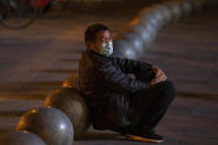 A man wearing a mask rests near barriers outside a shopping mall in Beijing on Friday, Oct. 30, 2020. China has managed to stem the spread of the coronavirus within the country even as the pandemic continues to surge globally. (AP Photo/Ng Han Guan)