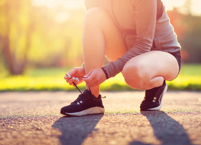 mujer abrochándose las zapatillas de running