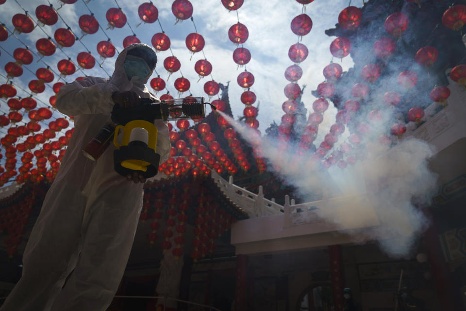 A worker disinfects the Thean Hou Temple during during first day of Chinese Lunar New Year celebrations in Kuala Lumpur, Friday, Feb. 12, 2021. The movement control order (MCO) currently enforced across the country to help curb the spread of the coronavirus, has been extended to Feb. 18, effectively covering the Chinese New Year festival that falls on Feb. 12 this year. (AP Photo/Vincent Thian)
