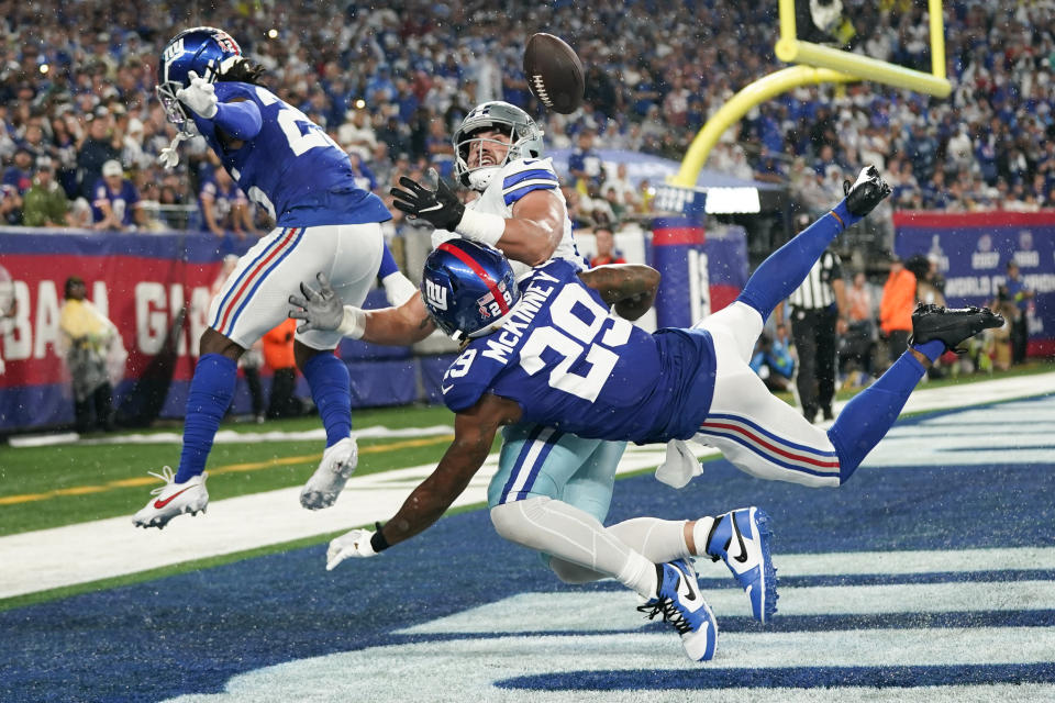 New York Giants' Deonte Banks, left, and Xavier McKinney, bottom right, break up a pass intended for Dallas Cowboys' Jake Ferguson during the first half of an NFL football game, Sunday, Sept. 10, 2023, in East Rutherford, N.J. (AP Photo/Bryan Woolston)