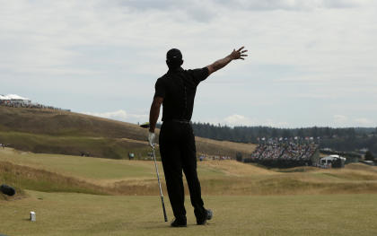 Tiger Woods watches his tee shot on the eighth hole veer right at Chambers Bay. (AP)