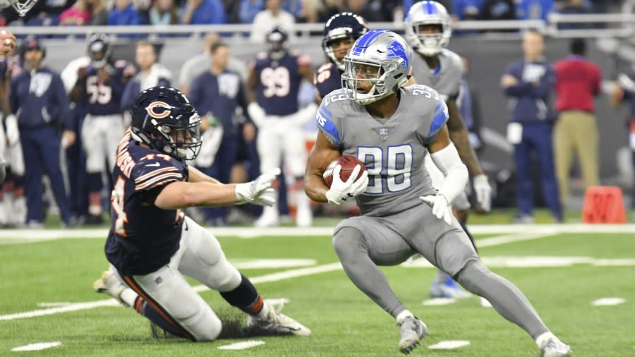 Jamal Agnew, sporting the Lions steel-gray Color Rush uniform, makes a cut to avoid a tackle by a Bears player.