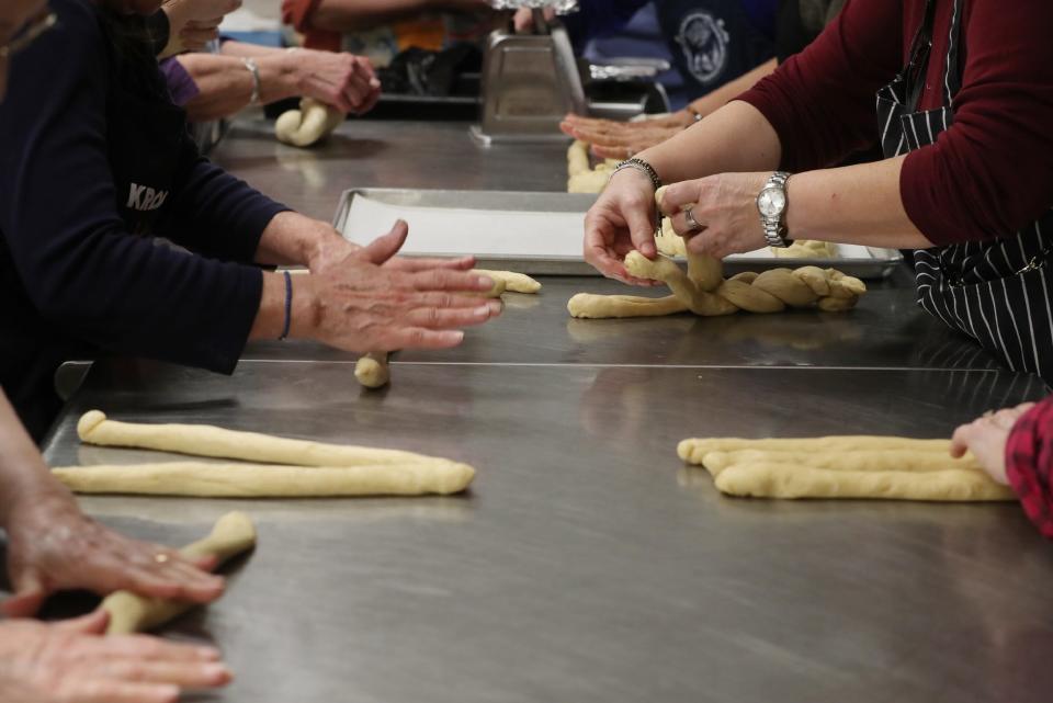 Volunteer bakers from Annunciation's Philoptochos Society and Archangel Michael Kalymnian Society of Campbell, Ohio, roll and braid dough to make tsourekia, braided Easter bread, at Annunciation Greek Orthodox Church in Akron Tuesday.