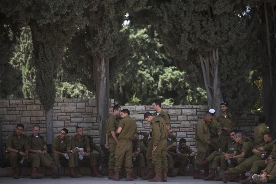 Israeli soldiers rest during preparations for Memorial Day ceremonies at Kiryat Shaul Military cemetery in Tel Aviv, Israel, Sunday, May 4, 2014. Israel will mark the annual Memorial Day in remembrance of soldiers who died in the nation's conflicts, beginning at dusk Sunday until Monday evening. (AP Photo/Oded Balilty)