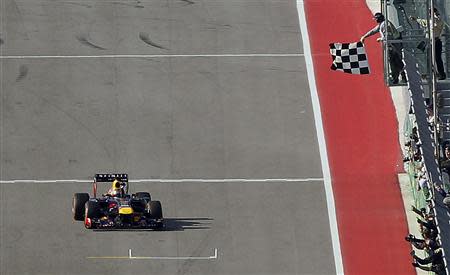 Red Bull Formula One driver Sebastian Vettel of Germany takes the checkered flag to win the Austin F1 Grand Prix at the Circuit of the Americas in Austin November 17, 2013. REUTERS/Mike Stone