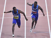 Christian Coleman, of the United States, left, crosses the finish line to win the men's 100 meter race ahead of silver medalist Justin Gatlin, of the United States, right, during the World Athletics Championships in Doha, Qatar, Saturday, Sept. 28, 2019. (AP Photo/Martin Meissner)