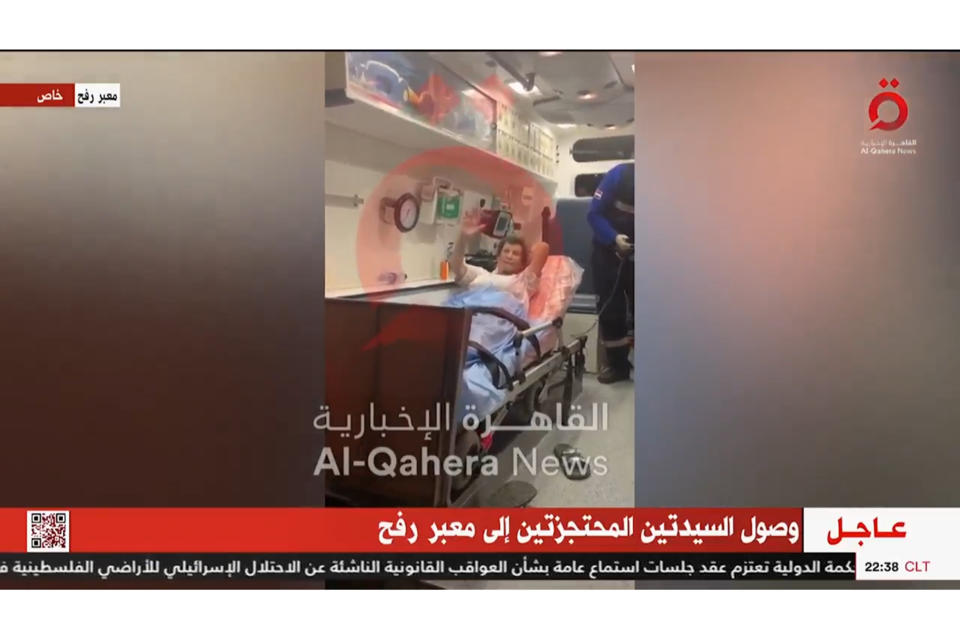 In this image taken from video released by al-Qahera News, Yocheved Lifshitz, 85, waves from an ambulance at the Rafah border crossing, Monday, Oct. 23, 2023, after being released by Hamas militants. (al-Qahera News via AP)