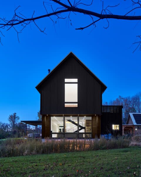 All-black exterior cladding includes charred wood siding by reSAWN, and corrugated metal siding by ATAS. A standing seam metal roof, also by ATAS, completes the striking monotone envelope.