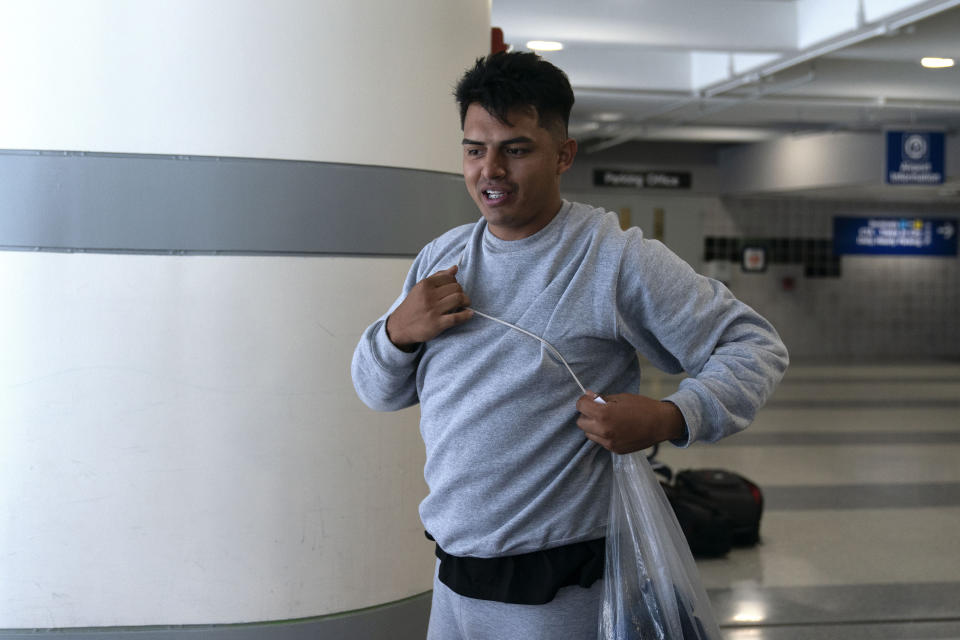 Jhonatan Gelvez, 21, of Colombia, packs up his things at a makeshift shelter for migrants at O'Hare International Airport, Wednesday, Sept. 20, 2023, in Chicago. Fleeing violence in his home country, Gelvez and his fianceé were separated when detained at the border. He awaits her release and their reunification. (AP Photo/Erin Hooley)