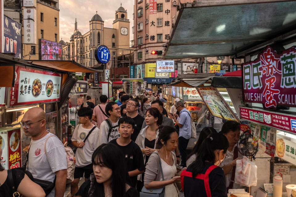 Shoppers pass food stalls at a night market in Taipei. (Photo: Lam Yik Fei/Bloomberg)