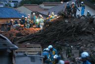 Police officers search for missing people, one day after a landslide hit a residential area in Hiroshima, western Japan on August 21, 2014