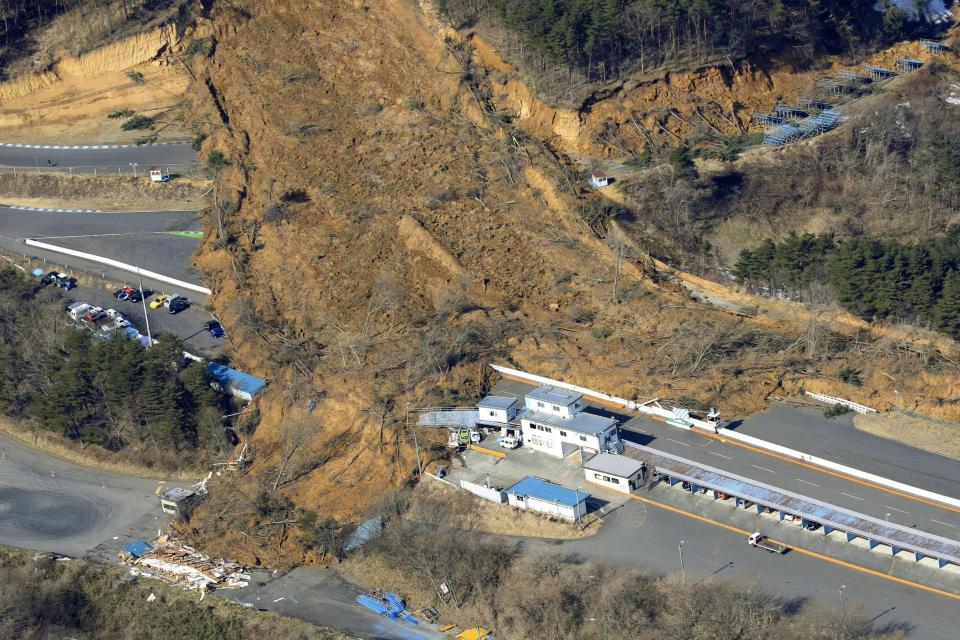 FILE - A landslide caused by a strong earthquake covers a circuit course in Nihonmatsu city, Fukushima prefecture, northeastern Japan, Feb. 14, 2021. As fossil fuel use that feeds climate change is creeping up around the world, Japan is set for another sweltering summer following last year’s dangerous heat waves and is at growing risk of flooding and landslides. (Hironori Asakawa/Kyodo News via AP, File)