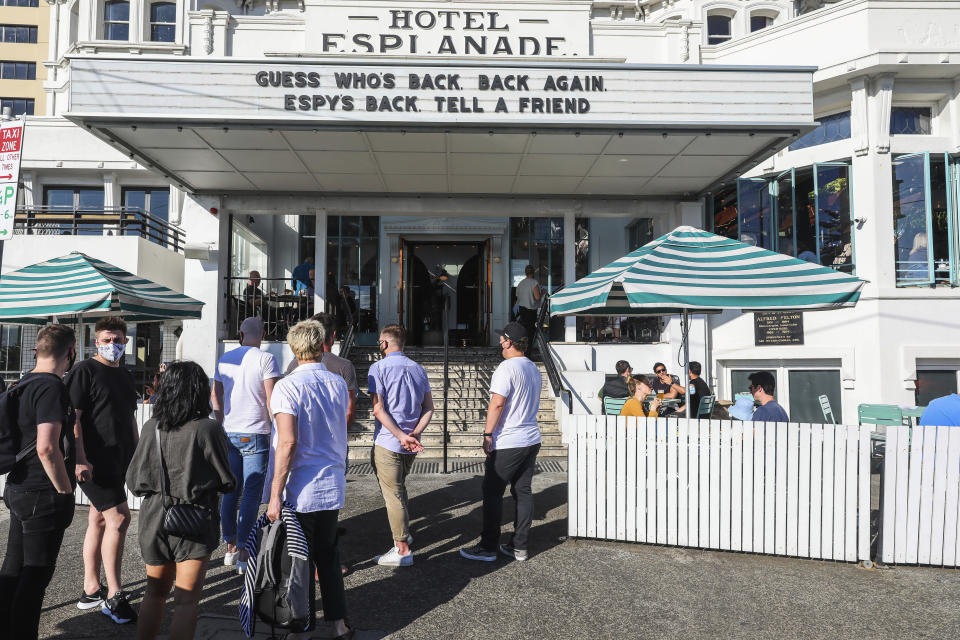 People line up outside a popular pub and restaurant in St Kilda in Melbourne, Australia, Wednesday, Oct. 28, 2020. Melbourne, Australia's former coronavirus hot spot, emerged from a lockdown at midnight Tuesday, restaurants, cafes and bars were allowed to open and outdoor contact sports can resume. (AP Photo/Asanka Brendon Ratnayake)