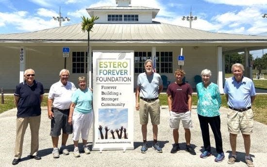 Volunteers stand ate the entrance to the Golf Coast Driving Range, which will close permanently on April 30.