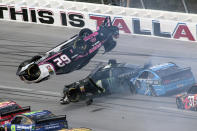 Brendan Gaughan (62) flips in Turn 3 as driver Kurt Busch (1) and David Ragan (38) pass underneath during a NASCAR Cup Series auto race at Talladega Superspeedway, Monday, Oct 14, 2019, in Talladega, Ala. (AP Photo/Greg McWilliams)