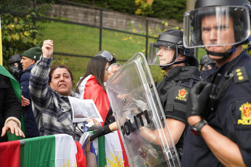 FILE - Policemen stand guard as demonstrators gather outside Iran's embassy in Oslo, Norway, Thursday, Sept. 29, 2022, to protest the death of 22-year-old Mahsa Amini in custody in Iran after she was detained by the country's morality police. As anti-government protests roil cities and towns in Iran for a fourth week, sparked by the death of Amini, tens of thousands of Iranians living abroad have marched on the streets of Europe, North America and beyond in support of what many believe to be a watershed moment for their home country. (Terje Pedersen/NTB Scanpix via AP, File)