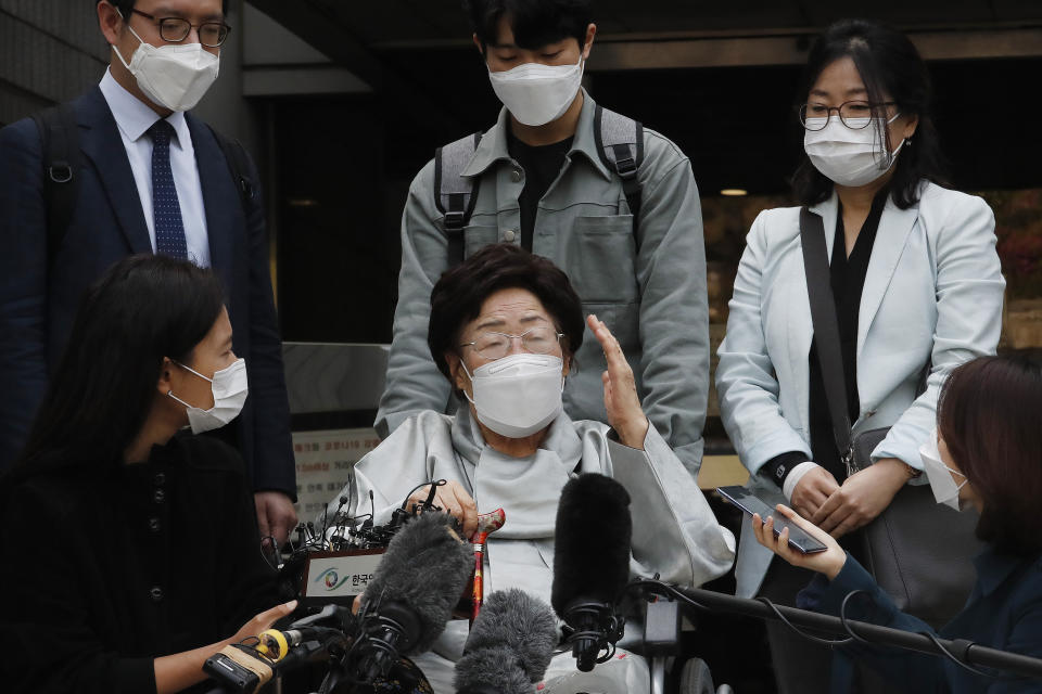 Former South Korean comfort woman Lee Yong-soo, center, speaks before leaving the Seoul Central District Court in Seoul, South Korea, Wednesday, April 21, 2021. The court on Wednesday rejected a claim by South Korean sexual slavery victims and their relatives who sought compensation from the Japanese government over their wartime sufferings. (AP Photo/Ahn Young-joon)