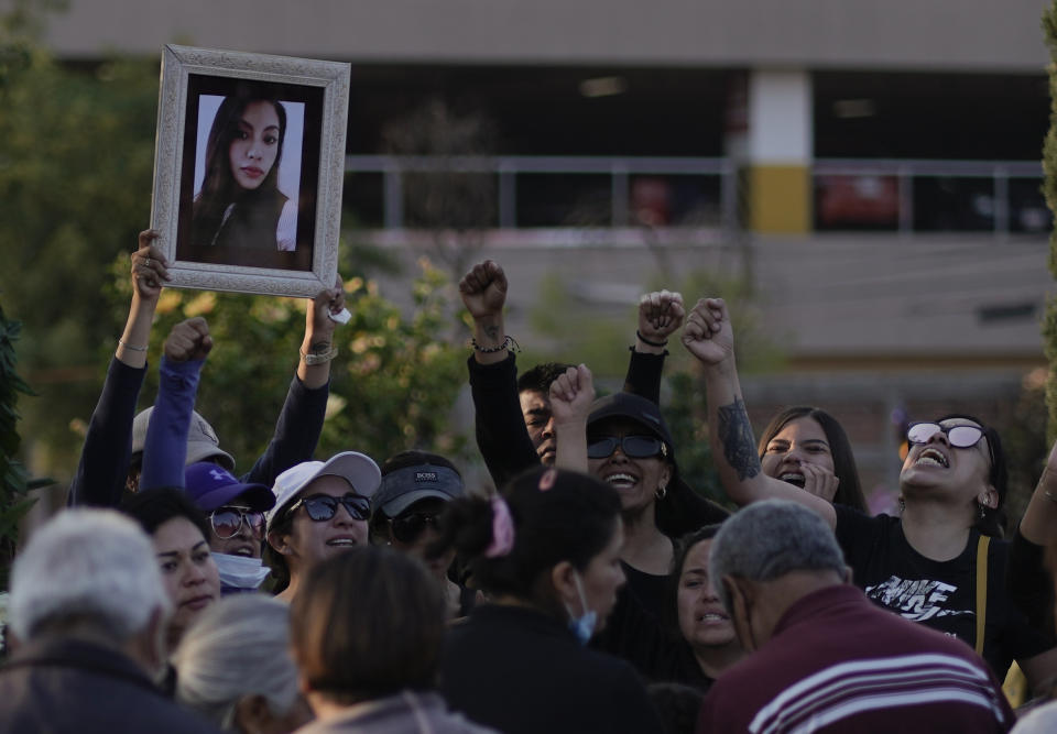 Friends of slain Monica Citlalli Diaz shout "justice" as they hold up her photo during her funeral in Ecatepec, State of Mexico, Mexico, Friday, Nov. 11, 2022. The 30-year-old English teacher became the ninth apparent femicide during an 11-day spate of killings in and around Mexico City from late October to early November. (AP Photo/Eduardo Verdugo)