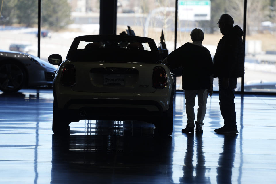 FILE - Shoppers consider a 2022 Cooper convertible on display in a Mini dealership in Highlands Ranch, Colo., on Friday, Feb. 18, 2022. The Federal Reserve’s expected move Wednesday, July 26, 2023, to raise interest rates for the 11th time could once again send ripple effects across the economy. (AP Photo/David Zalubowski)
