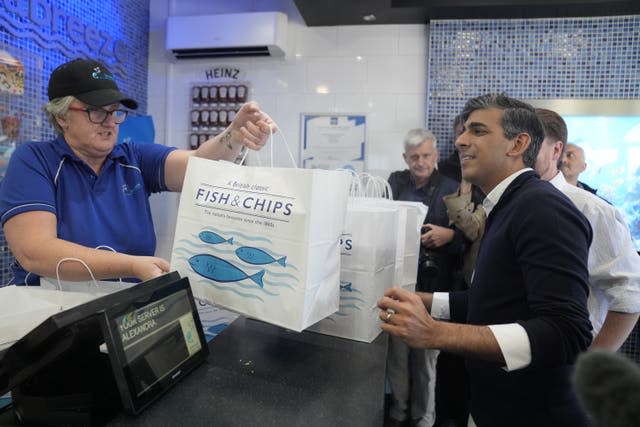 Rishi Sunak is handed bags of fish and chips