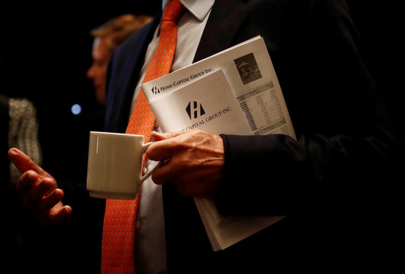 A man holds papers during the annual general meeting of Canada's biggest non-bank lender Home Capital in Toronto