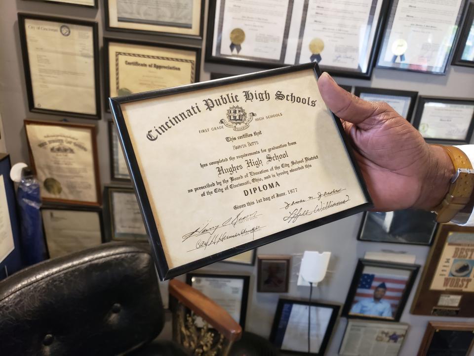 Marvin Butts, owner of Mr. Bubbles Detailing in Pendleton and founder of the Butts Family Foundation, holds his diploma from Hughes High School in his office on Monday, May 8, 2023. Butts, a 1977 graduate of Hughes, almost had his diploma withheld because he owed $35 in upaid school fees.
