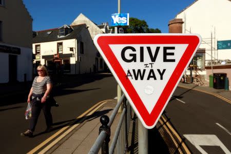 A vandalised road sign displays campaign graffiti in the town of Portree on the Isle of Skye September 17, 2014. REUTERS/Cathal McNaughton