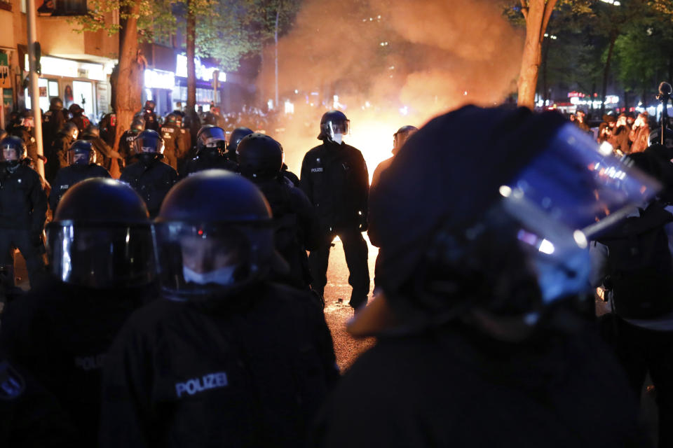 Policías antimotines montan guardia frente a una barricada con fuego creada por manifestantes, en una protesta por el Primero de Mayo en Berlín, el sábado 1 de mayo de 2021. (AP Foto/Markus Schreiber)