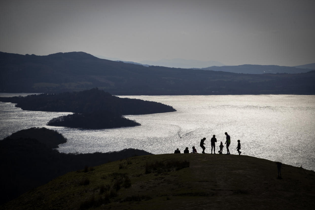 A family looks out across Loch Lomond from Conic Hill, near Balmaha.